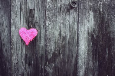 Ahşap, yıpranmış arka planda dekoratif küçük bir kalp..