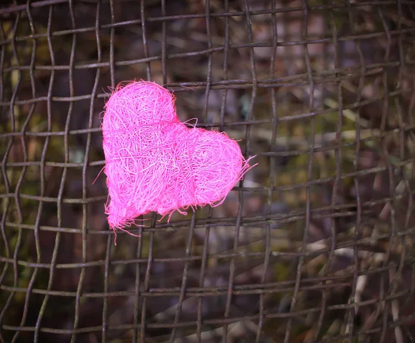 Corazón decorativo colorido sobre fondo de tamiz de hierro rústico viejo. foto conceptual . — Foto de Stock