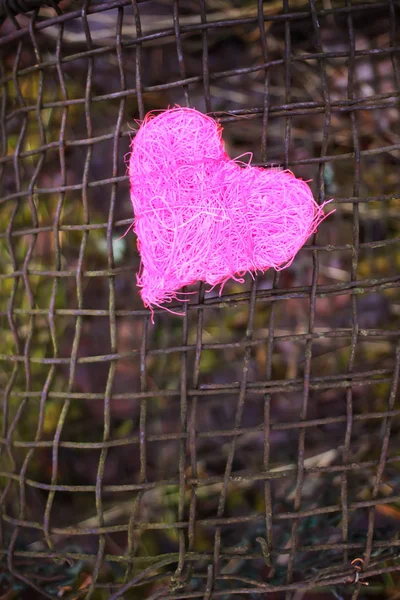 Corazón decorativo colorido sobre fondo de tamiz de hierro rústico viejo. foto conceptual . — Foto de Stock