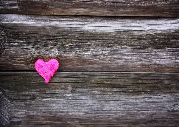 Corazón pequeño decorativo sobre fondo envejecido de madera . — Foto de Stock