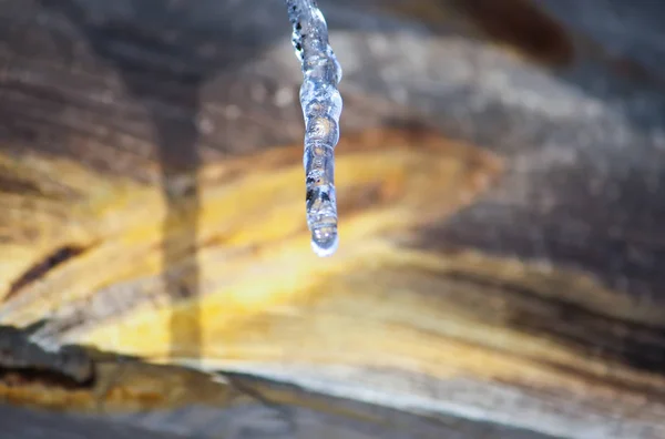 Brillantes carámbanos transparentes colgando en un techo de cerca . —  Fotos de Stock