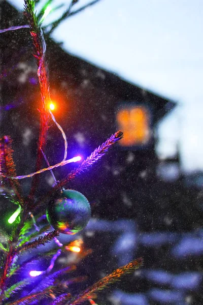 Abeto decorado ao ar livre no fundo da casa rural. Férias de inverno fundo festivo . — Fotografia de Stock
