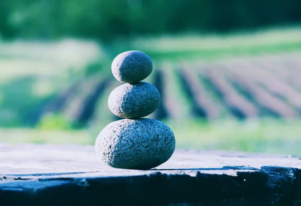 Drei Steine auf einem Holztisch — Stockfoto