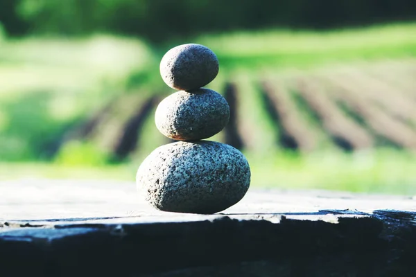 Tre stenar på ett träbord — Stockfoto