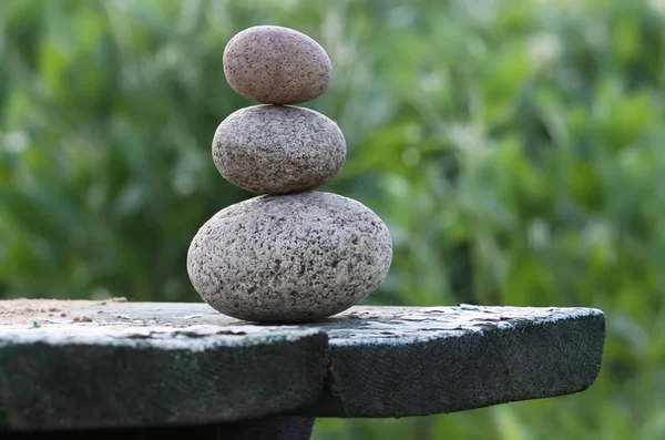 Three stones on a wooden table — 스톡 사진