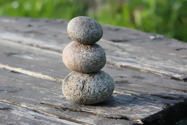 Tres piedras sobre una mesa de madera —  Fotos de Stock