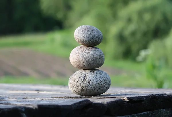 木桌上的三块石头 — 图库照片