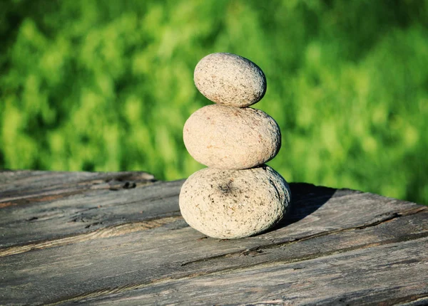 Drei Steine auf einem Holztisch — Stockfoto