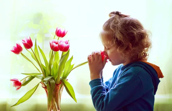 Little girl with bouquet of tulip flowers. — Stock Photo, Image