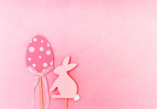 Composition de Pâques avec décor traditionnel. Figures décoratives en bois d'oeuf et de lapin sur fond rose clair doux . — Photo