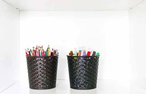 Цветные карандаши в черном органайзере на белом фоне полки — стоковое фото