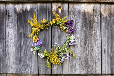 Eski ahşap arka planda yabani çiçeklerin çelengi.