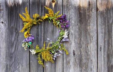 Eski ahşap arka planda yabani çiçeklerin çelengi.