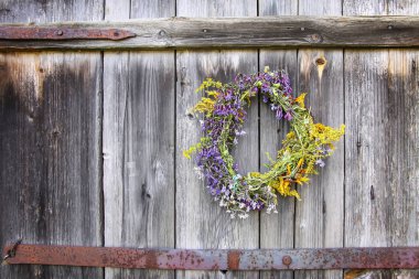 Eski ahşap arka planda yabani çiçeklerin çelengi.
