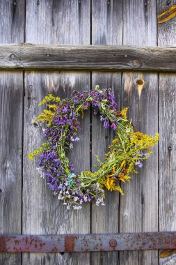 Eski ahşap arka planda yabani çiçeklerin çelengi.