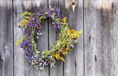 Eski ahşap arka planda yabani çiçeklerin çelengi.