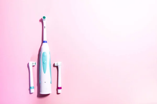 Dos cepillos de dientes eléctricos sobre un fondo rosa claro suave —  Fotos de Stock