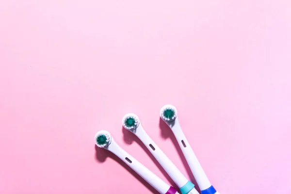 Dwie elektryczne szczoteczki do zębów na miękkim jasnoróżowym tle — Zdjęcie stockowe