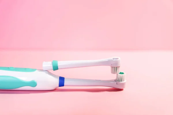 Two electrical toothbrushes on a soft light pink background — 스톡 사진