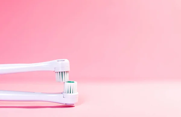Two electrical toothbrushes on a soft light pink background — Stock Photo, Image