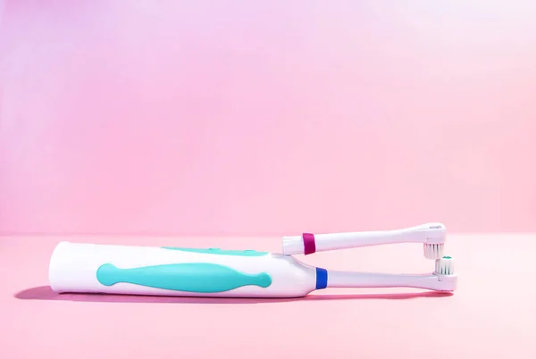 Two electrical toothbrushes on a soft light pink background — Stock Photo, Image