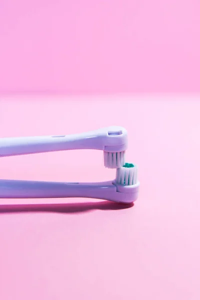 Two electrical toothbrushes on a soft light pink background — Stock Photo, Image