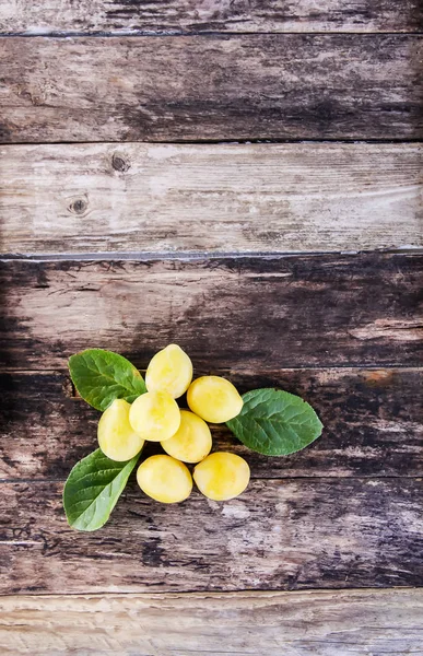 Yellow plums. Fresh ripe sweet fruits on old wooden boards rough background
