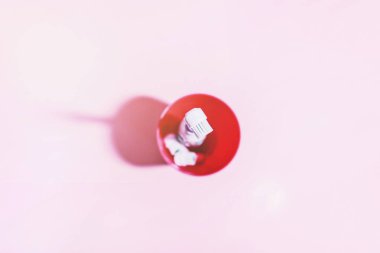 Yumuşak açık pembe arka planda iki elektrikli diş fırçası.