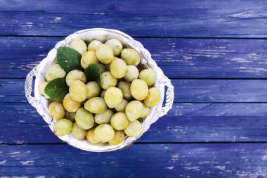 Taze sarı erikler. Mavi tahta arka planda olgun meyveler.