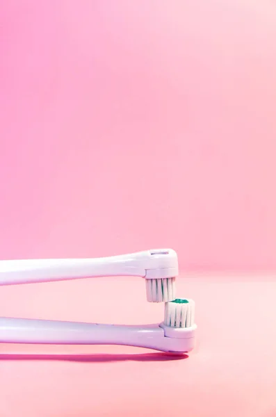 Two electrical toothbrushes on a soft light pink background — Stock Photo, Image