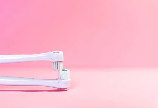 Two electrical toothbrushes on a soft light pink background — Stock Photo, Image