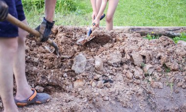 Adam kürekle toprağı kazıyor.