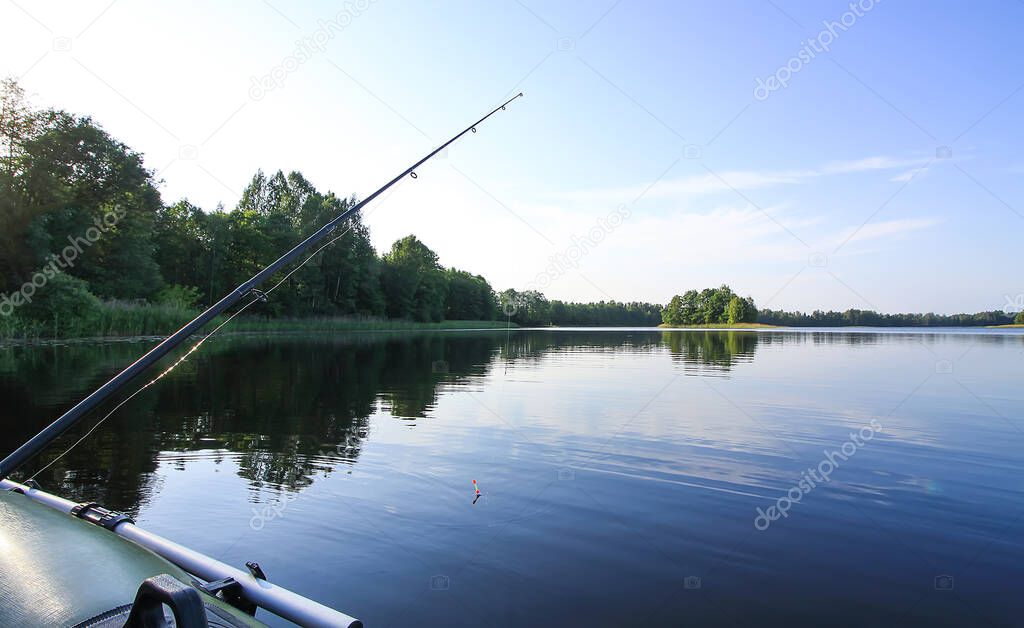 Spinning with reel on evening lake background.