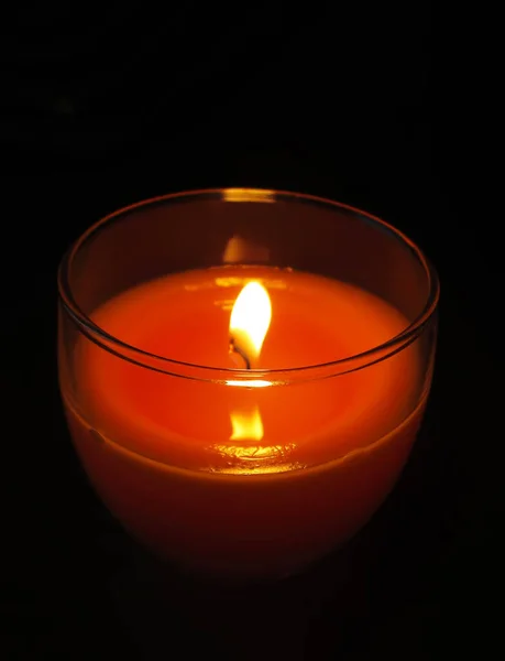 透明玻璃烛台上的红色蜡烛在黑暗中燃烧 — 图库照片