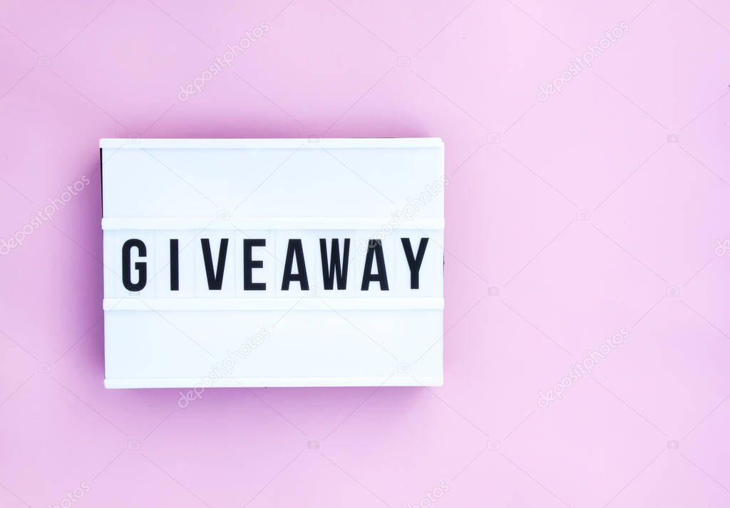 Giveaway word on the white display on pink background
