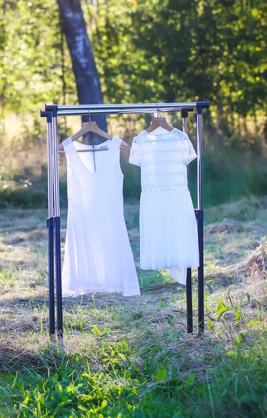 Linen dresses hanging on a hanger outdoors in summer day