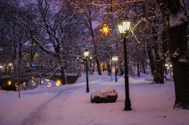 Karla kaplı Riga parkında bayram fenerleri.