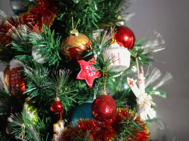 Noel ağacı dallarında parıldayan mücevherler ve süsler.