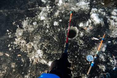 Bir adam kışın buzda balık tutuyor. Balık tutma kış