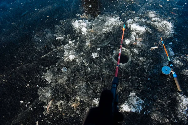 Un hombre está pescando en el hielo en invierno. Pesca de invierno — Foto de Stock