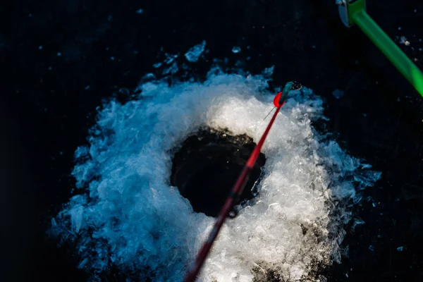 Un hombre está pescando en el hielo en invierno. Pesca de invierno — Foto de Stock