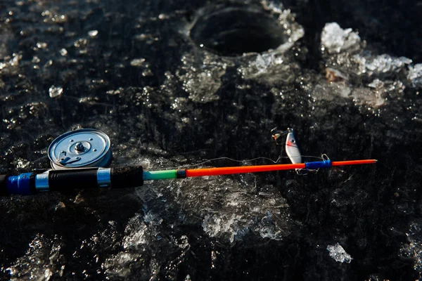 Caña de pescar para la pesca de invierno se encuentra en el hielo en invierno . — Foto de Stock