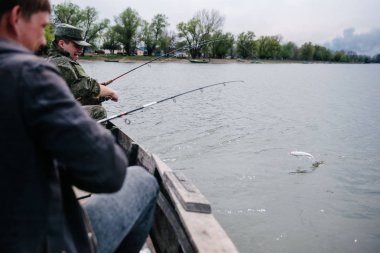 Balıkçılar teknede oturan balık yakalamak