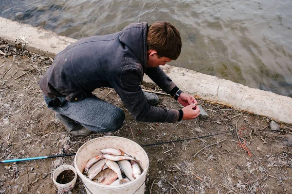 Pescador pone un gusano en el gancho —  Fotos de Stock