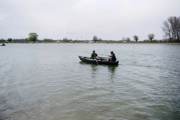 Pescadores atrapan peces sentados en el barco —  Fotos de Stock