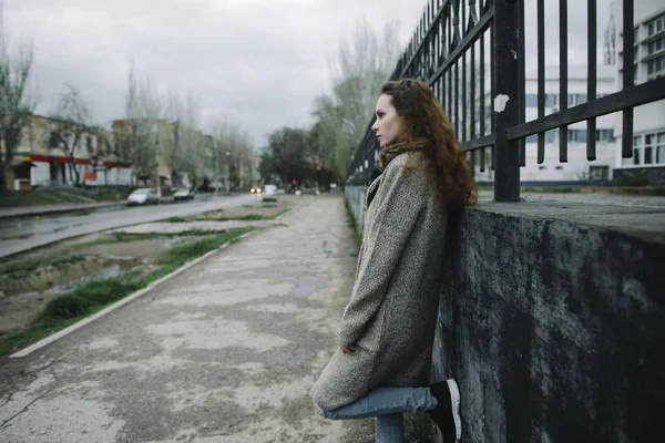 Молодая женщина позирует на улице в коричневом кардигане — стоковое фото