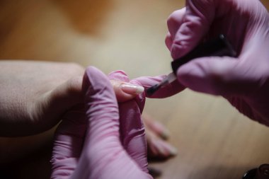 Manikürcü yakın tırnak üzerinde vernik uygular