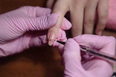 Manikürcü yakın tırnak üzerinde vernik uygular