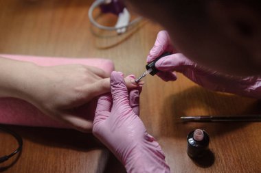 Manikürcü yakın tırnak üzerinde vernik uygular