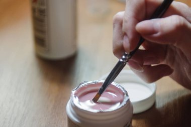 Manikürcü yakın tırnak üzerinde vernik uygular